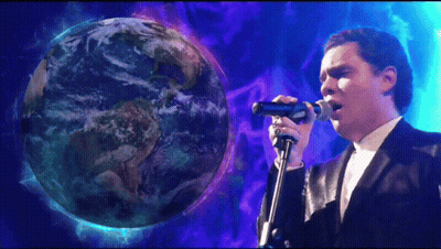 Man Singing Into Microphone In Front Of Globe GIF