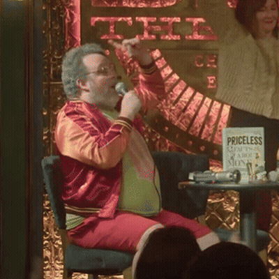 Man Singing Into Microphone In Front Of Priceless Sign GIF