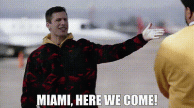 Man Singing Into Microphone In Front Of Welcome To Miami Sign GIF