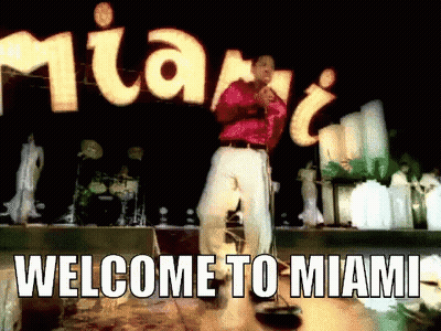 Man Singing Into Microphone In Front Of Welcome To Miami Sign GIF