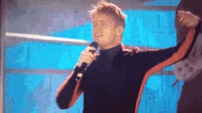 Man Singing Into Microphone In Front Of Window GIF