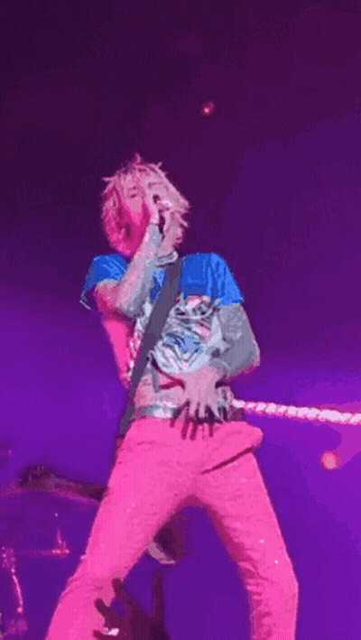 Man Singing Into Microphone In Pink Pants And Blue Shirt GIF