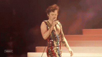 Man Singing Into Microphone In Sequined Outfit GIF