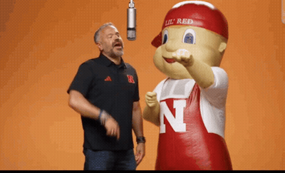 Man Singing Into Microphone Next To Mascot With Letter N GIF