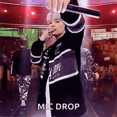 Man Singing Into Microphone On Stage Before Crowd GIF