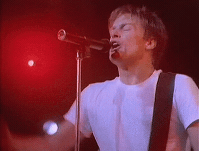 Man Singing Into Microphone On Stage GIF
