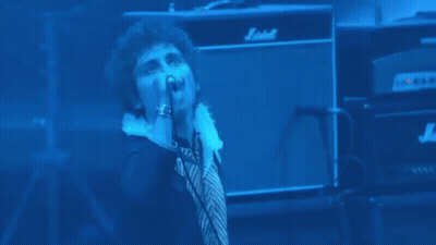 Man Singing Into Microphone On Stage GIF
