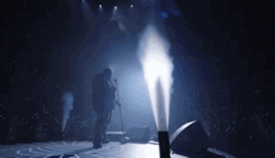 Man Singing Into Microphone On Stage With Smoke GIF