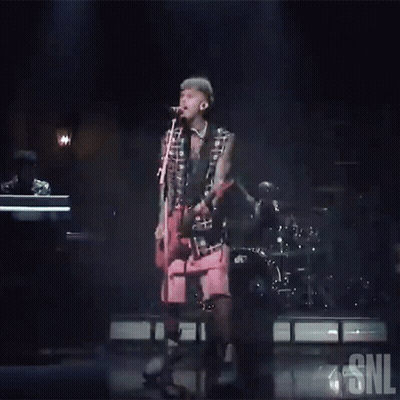 Man Singing Into Microphone On Stage With SNL Logo GIF