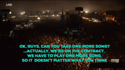 Man Singing Into Microphone Playing Guitar And Drums GIF