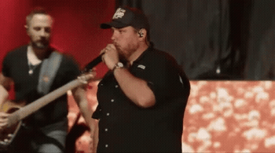 Man Singing Into Microphone Playing Guitar On Stage GIF