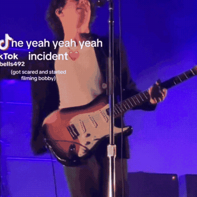 Man Singing Into Microphone Playing Guitar Purple Background GIF