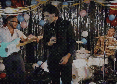 Man Singing Into Microphone Playing Guitar With Balloons GIF
