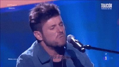 Man Singing Into Microphone Playing Piano Blue Background Traicion GIF