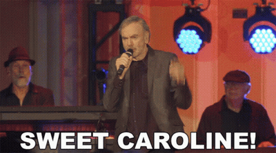 hombre cantando al micrófono Sweet Caroline GIF