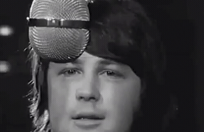 Man Singing Into Microphone Wearing Hat GIF