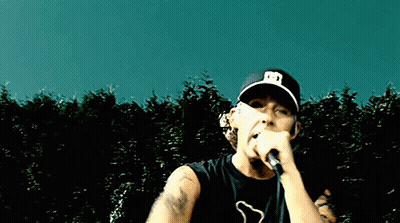 Man Singing Into Microphone Wearing Hat With Letter E GIF