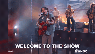 Hombre cantando al micrófono 'Bienvenido al show' GIF