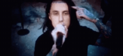 Man Singing Into Microphone While Another Holds His Hair GIF