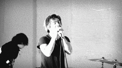 Man Singing Into Microphone While Another Watches GIF