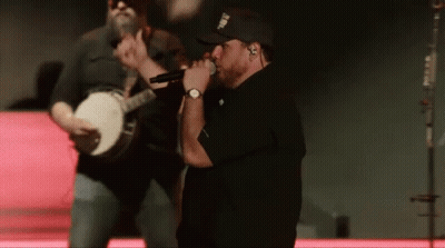 Man Singing Into Microphone While Banjo Player Plays GIF