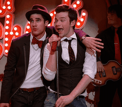 Man Singing Into Microphone With Another Behind GIF