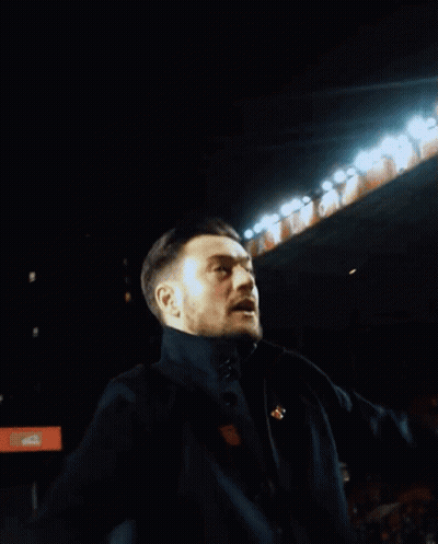 Man Singing Into Microphone With Arms Up GIF