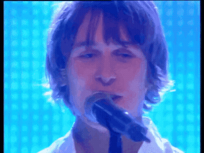 Man Singing Into Microphone With Blue Background GIF