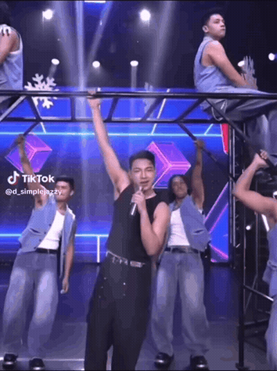 Man Singing Into Microphone With Dancing Men GIF