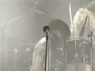 Man Singing Into Microphone With Drummer GIF