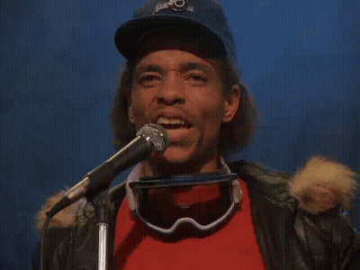 Man Singing Into Microphone With Goggles And Hat GIF