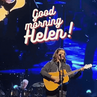 Man Singing Into Microphone With Good Morning Helen Sign