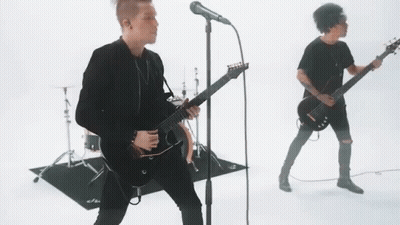 Man Singing Into Microphone With Guitarist And Drums GIF