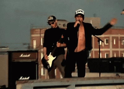 Man Singing Into Microphone With Guitarist GIF