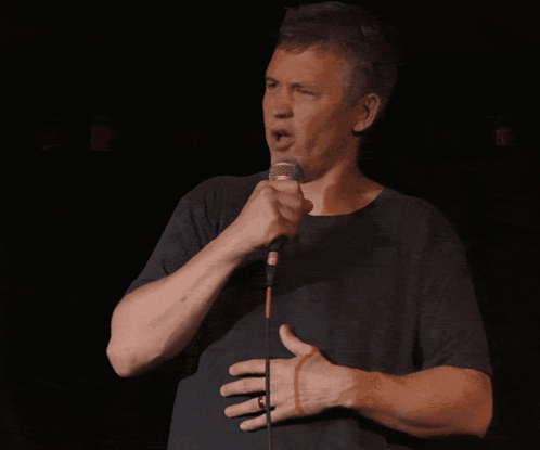 Man Singing Into Microphone With Hand On Stomach GIF