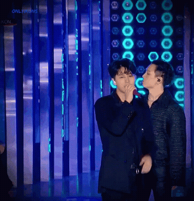 Man Singing Into Microphone With Kon Sign GIF