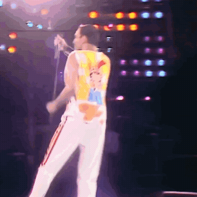Man Singing Into Microphone With Queen Shirt GIF