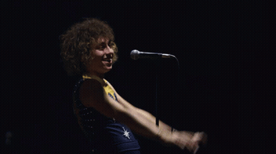 Man Singing Into Microphone With Star Shirt GIF