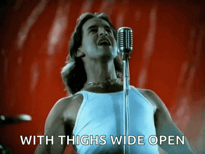 Man Singing Into Microphone With Thighs Wide Open GIF