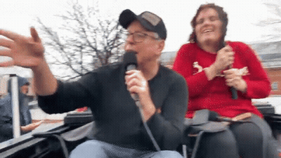 Man Singing Into Microphone With Woman Behind GIF