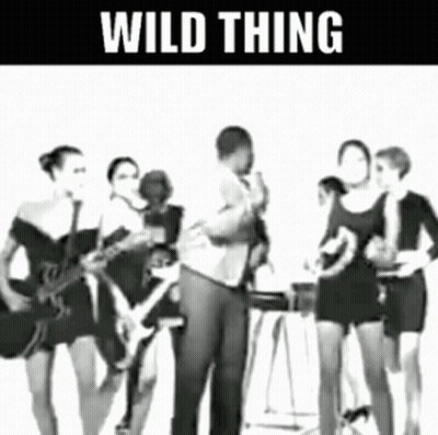 Man Singing Into Microphone With Women Playing Guitars GIF