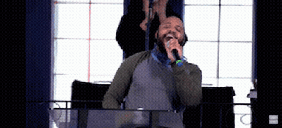 Man Singing Into Microphone Woman Behind Him GIF