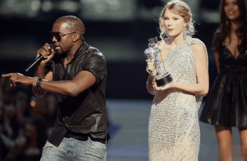 Man Singing Into Microphone Woman Holding Trophy