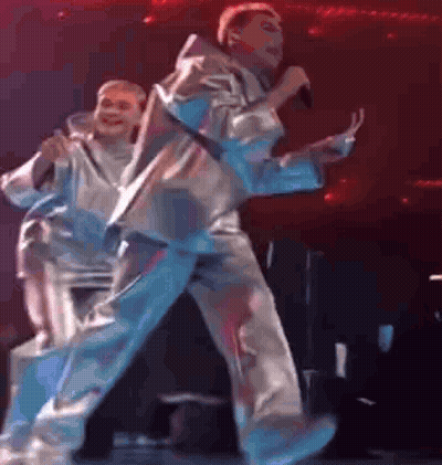 Man Singing On Stage With Dancer Behind GIF