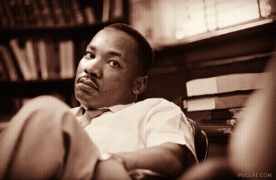 Man Sits In Front Of Bookshelf Muglife.com GIF