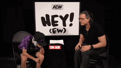 Man Sits In Front Of Sign Saying Hey (Ew) GIF