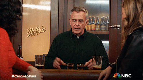 Man Sitting At Bar With Molly's Pub Behind Him GIF