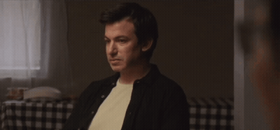 Man Sitting At Checkered Table Talking To Another Man GIF