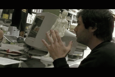 Man Sitting At Dell Computer Holding Statue GIF