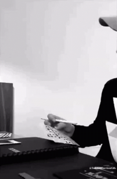 Man Sitting At Desk Holding Paper GIF